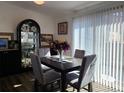 Cozy dining room with a dark wood table, grey chairs, and natural light streaming through the window blinds at 9133 W Cedar Dr # A, Lakewood, CO 80226