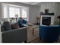 Bright living room featuring plush seating, a stone fireplace, and a large bay window for ample natural light at 9133 W Cedar Dr # A, Lakewood, CO 80226