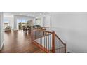 Bright foyer with hardwood floors and staircase leading to the upper level, featuring a glimpse of a sunlit dining area at 7814 S Grand Baker Ct, Aurora, CO 80016