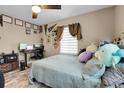 Spacious bedroom with a queen bed, workspace, and ceiling fan at 5065 Eliot St, Denver, CO 80221