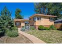 Beautiful single-Gathering brick house showcasing a cozy front patio and lush green surroundings on a sunny day at 1497 S Garfield St, Denver, CO 80210
