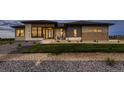 Well-manicured lawn leads to a modern home with stone accents, large windows, and an inviting entrance at 8868 Geyser Peak Way, Parker, CO 80138