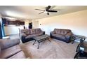 Spacious living room with comfortable seating, a ceiling fan, and a view of the kitchen area at 47373 Lily Ave, Bennett, CO 80102