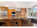 Chef's kitchen showcasing a large island with granite countertops, pendant lighting and stainless appliances at 1690 Bassett St # 6, Denver, CO 80202