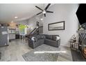 Open living room featuring high vaulted ceilings, gray walls and flooring, and a cozy sectional sofa at 10177 E Peakview Ave, Englewood, CO 80111