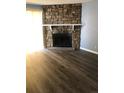 Living room with stone fireplace, wood-look floors, and a neutral color scheme at 14493 E Jewell Ave # 102, Aurora, CO 80012