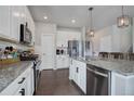 Modern kitchen with white cabinets, granite counters, and stainless steel appliances at 3934 Alamosa Ct, Brighton, CO 80601