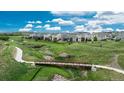 Scenic aerial view of a neighborhood with lush green spaces, walking trails, and a picturesque bridge at 4025 Trail Stone Cir, Castle Rock, CO 80108