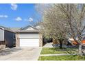 Charming home with a stone facade, attached two-car garage, and a well-maintained front yard at 765 Freestone St, Brighton, CO 80603