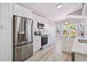 Updated kitchen with stainless steel refrigerator and range, white cabinets and subway tile backsplash at 765 Freestone St, Brighton, CO 80603