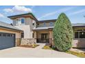 Close up of a home exterior highlighting a stone facade, large windows, and a well-maintained front yard at 4405 Fairway Ln, Broomfield, CO 80023