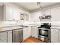 Bright kitchen with white cabinetry, stainless steel appliances, and recessed lighting at 695 S Alton Way # 9C, Denver, CO 80247