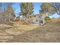 Spacious backyard with a large lawn, wooden retaining wall, and patio area at 6233 W 75Th Ave, Arvada, CO 80003