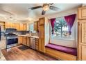 Bright kitchen featuring wood cabinets, stainless steel appliances, granite countertops, and a window bench at 6233 W 75Th Ave, Arvada, CO 80003