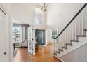 Bright foyer showcasing hardwood floors, staircase, and a soaring window above the front door at 532 Adam Pl, Castle Pines, CO 80108