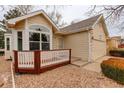 Cozy single-story home featuring a two-car garage and a charming front porch with decorative stone accents at 6522 S Hoyt Way, Littleton, CO 80123