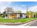 Stylish modern home with a well-manicured lawn, attractive wood accents, and a cozy seating area at 401 S Ivy St, Denver, CO 80224