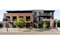 Contemporary mixed-use building featuring brick and metal accents, with retail spaces on the ground floor and residential above at 3420 W 32Nd Ave # 203, Denver, CO 80211