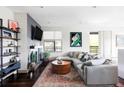 Bright living room with large sectional sofa, stylish round coffee table, fireplace, and shelving, creating a cozy ambiance at 3420 W 32Nd Ave # 203, Denver, CO 80211
