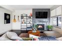 Cozy living room features a fireplace, TV, guitar, dart board, and a comfortable seating arrangement at 3420 W 32Nd Ave # 203, Denver, CO 80211