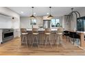 Bright kitchen showcasing a large center island with bar seating, stainless steel appliances, and hardwood floors at 8079 W 67Th Ave, Arvada, CO 80004