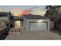 Lovely exterior view of home featuring stone accents, two-car garage and warm lighting at 6301 Perry Park Blvd # 22, Larkspur, CO 80118