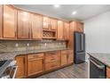 Bright kitchen showcasing wood cabinets, dark stainless steel appliances, and beautiful granite countertops at 7865 Vallagio Ln # 308, Englewood, CO 80112