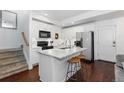 Modern white kitchen with marble island and stainless steel appliances at 9624 Martin Luther King Blvd, Denver, CO 80238