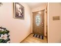 Warm and inviting foyer with hardwood floors and decorative front door at 1462 S Dudley St, Lakewood, CO 80232