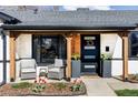Inviting front porch with modern black door, sleek planters, and seating at 1248 Ursula St, Aurora, CO 80011