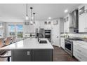 Modern kitchen with white cabinetry, gray accents, a large island with seating, and stainless steel appliances at 21102 E Stanford Dr, Aurora, CO 80015