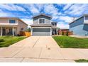 Exterior view of home with an expansive concrete driveway and well-manicured lawn at 4184 Netherland St, Denver, CO 80249