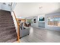 Open-concept living area with hardwood floors and stairs leading to the upper level at 4184 Netherland St, Denver, CO 80249