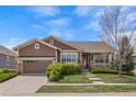 Charming ranch-style home with a well-manicured lawn, mature landscaping, and covered front porch at 21780 E Heritage Pkwy, Aurora, CO 80016