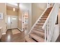 Bright entryway featuring a staircase and wood floors, leading to the rest of the home at 49 Dawn Heath Cir, Littleton, CO 80127