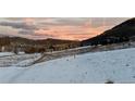 Enjoy stunning mountain views from this property's snowy backyard, perfect for a peaceful retreat at 5826 High Toll Trl, Morrison, CO 80465