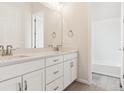 Modern bathroom featuring double sinks, white cabinetry, and access to a shower and tub at 4716 Twelve Oaks Way, Castle Rock, CO 80104