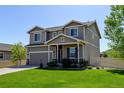 Charming two-story home with manicured lawn, covered porch, and attached garage at 11158 Carbondale St, Firestone, CO 80504