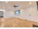 Bright living room featuring hardwood floors, large windows, ceiling fan, and neutral paint at 4244 W Monmouth Ave, Littleton, CO 80123