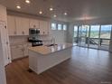 Bright kitchen boasts a large island, stainless steel appliances, and access to an outdoor deck at 4225 Ridgewalk Pt, Castle Rock, CO 80108