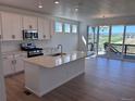 Modern kitchen features a large island, stainless steel appliances, and a sliding glass door leading to a deck with views at 4225 Ridgewalk Pt, Castle Rock, CO 80108