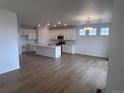Open concept eat-in kitchen features modern white cabinetry, stainless appliances, and hardwood floors at 4225 Ridgewalk Pt, Castle Rock, CO 80108