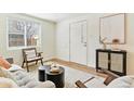 Bright living room featuring light wood floors, a modern rug, and a large window that brings in natural light at 2550 Kendall St, Edgewater, CO 80214