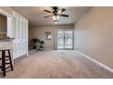 Spacious living room featuring plush carpet, a ceiling fan and sliding door access to the backyard at 5294 S Prescott St, Littleton, CO 80120