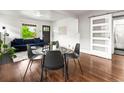 Dining area with a glass table, modern chairs, and hardwood floors adjacent to living room at 3458 N Clayton St, Denver, CO 80205