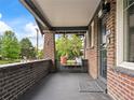 Inviting front porch with a comfortable bench, brick columns, and a 'welcome' mat at 3458 N Clayton St, Denver, CO 80205