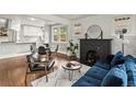 Cozy living room featuring a fireplace, blue sofa, and an open layout with the dining area at 3458 N Clayton St, Denver, CO 80205