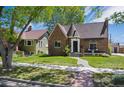 Charming brick home featuring a well-maintained lawn and a turret on a sunny day at 4434 Grove St, Denver, CO 80211