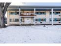 Charming condo building with snow covered front yard and balcony at 4980 E Donald Ave # 14, Denver, CO 80222