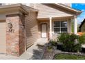 Inviting front entrance with brick accents, manicured landscaping, and a charming porch at 737 Novick Ct, Castle Rock, CO 80109